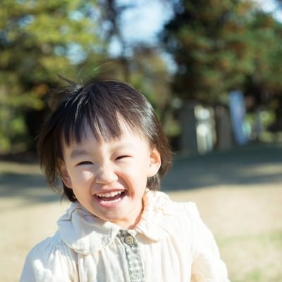 笑顔で公園を走り回る子供の写真