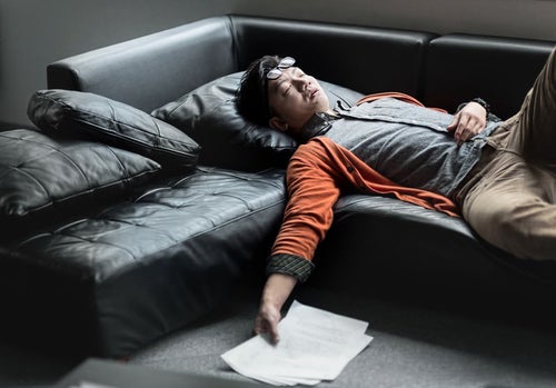 原稿を持ってソファーで寝落ちする担当の男性の写真