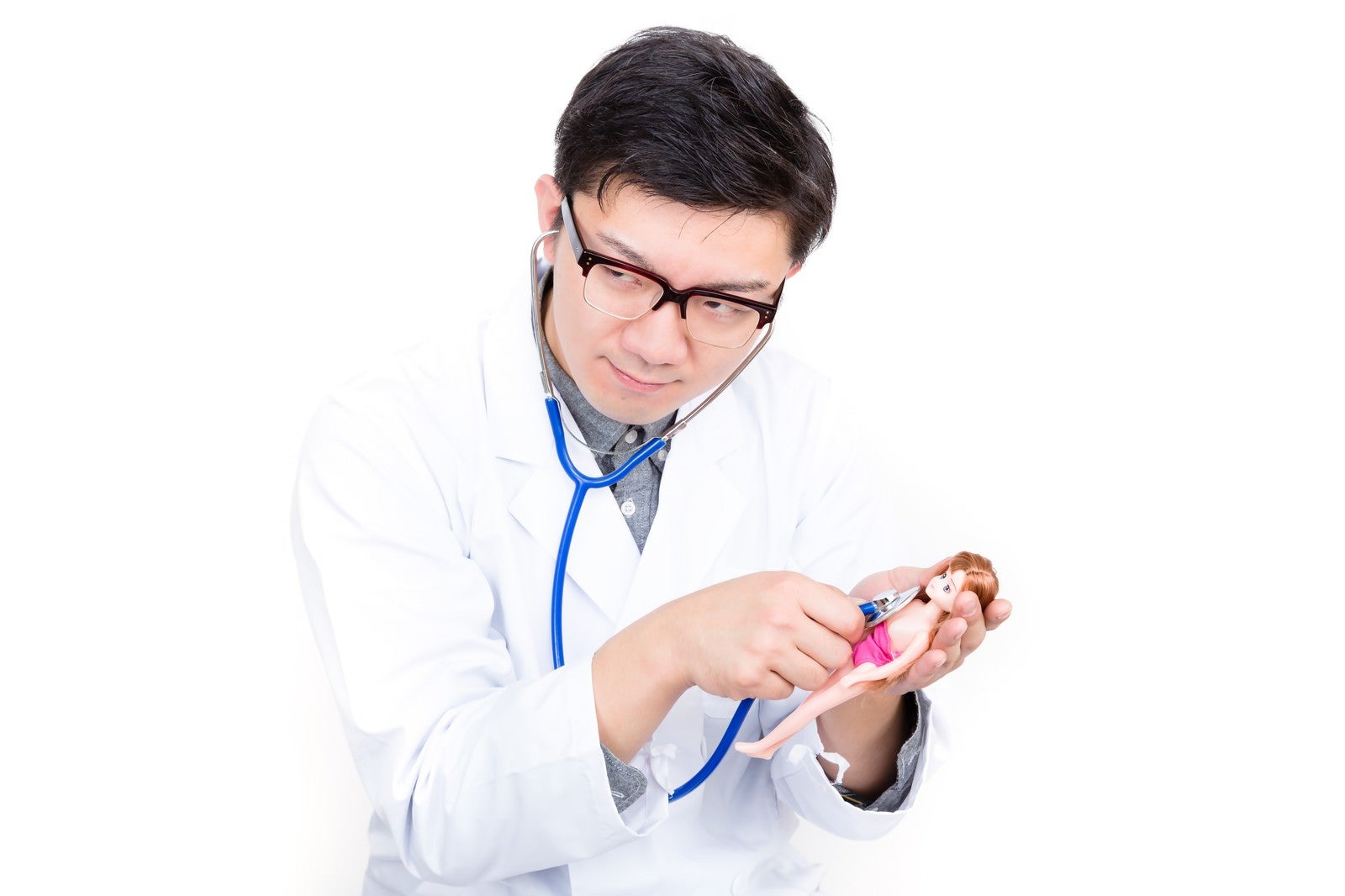「人形に聴診器を当ててお医者さんごっこをする男性」の写真［モデル：OZPA］