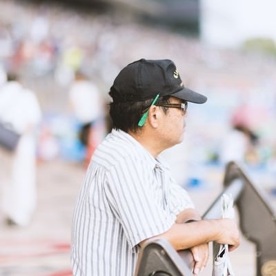 競馬新聞を片手に持つおじさんの写真