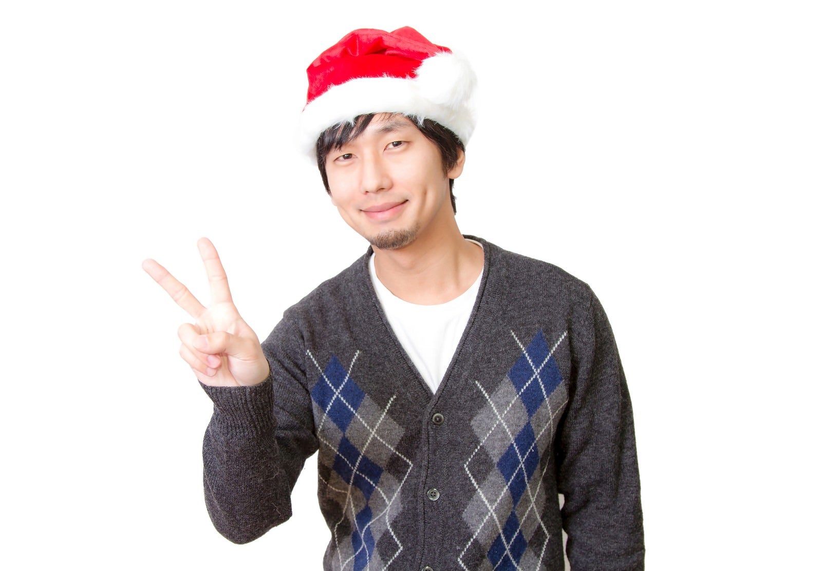 「サンタ帽をかぶってピースする男性」の写真［モデル：大川竜弥］