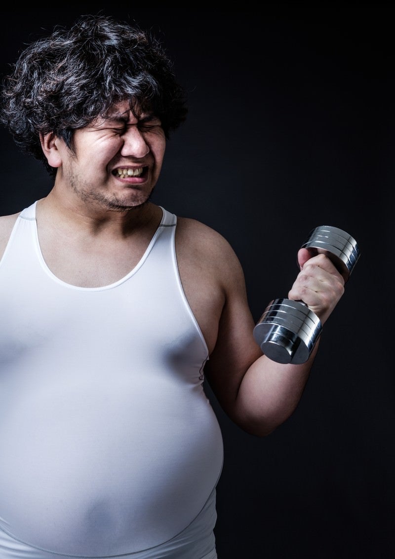 「ダンベルよりも贅肉が重そうな肥満男子」の写真［モデル：あまのじゃく］