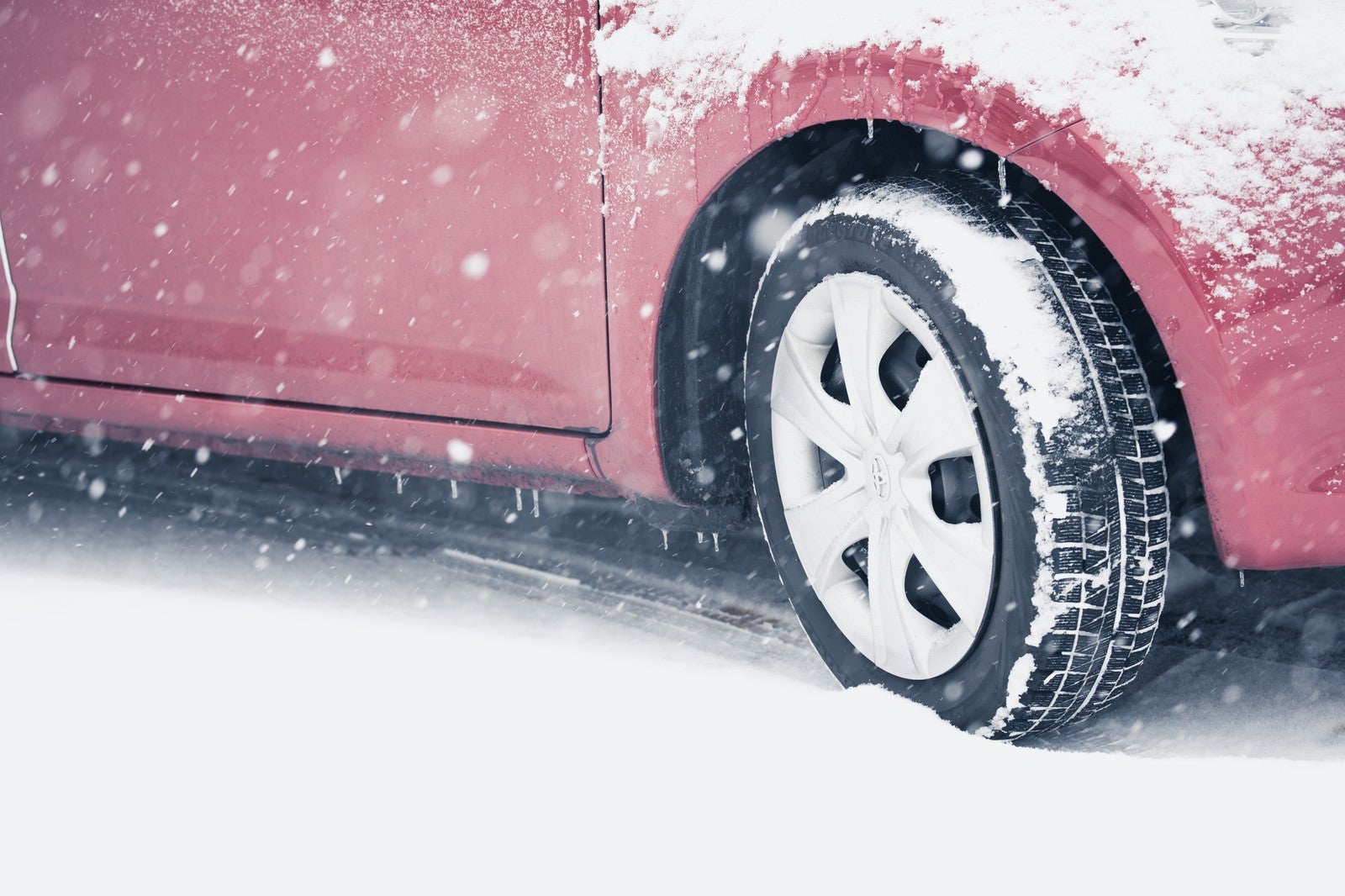 「スリップ注意！雪道を走行する車」の写真