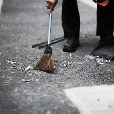 渋谷の街をチリトリとホウキで清掃する人の写真
