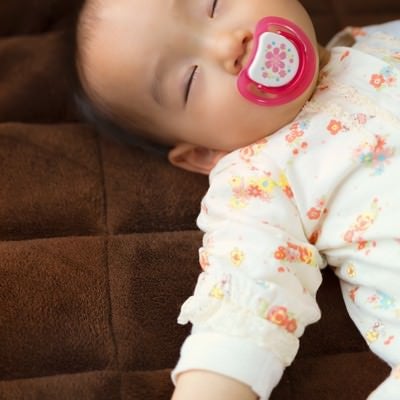 おしゃぶりを咥えながら眠る赤ちゃんの写真