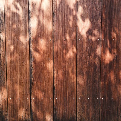 木漏れ日の影と木目調の壁（テクスチャー）の写真