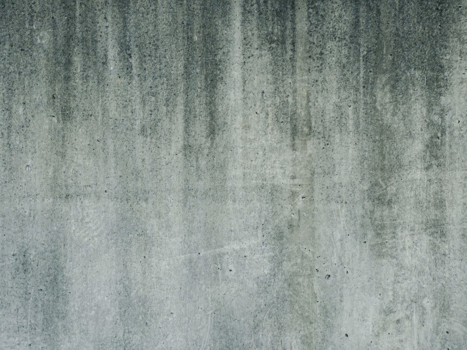 「汚れの流れた痕が残るコンクリートの壁（テクスチャー）」の写真