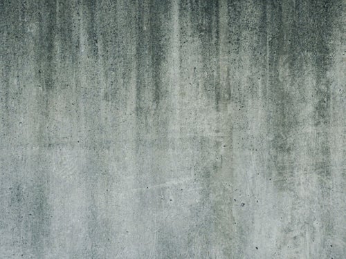 汚れの流れた痕が残るコンクリートの壁（テクスチャー）の写真