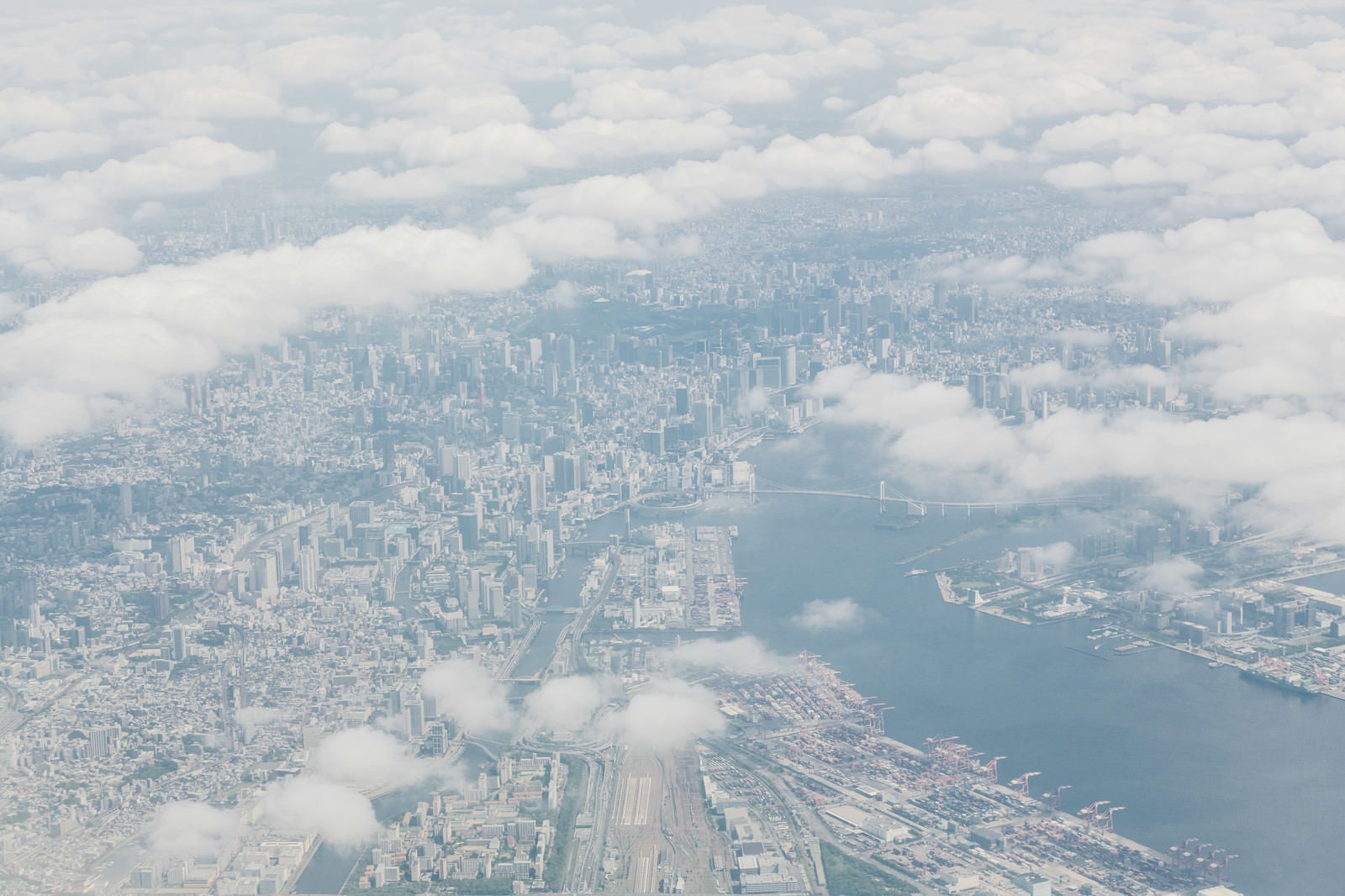 「雲の切れ目から見える東京の高層ビル郡」の写真