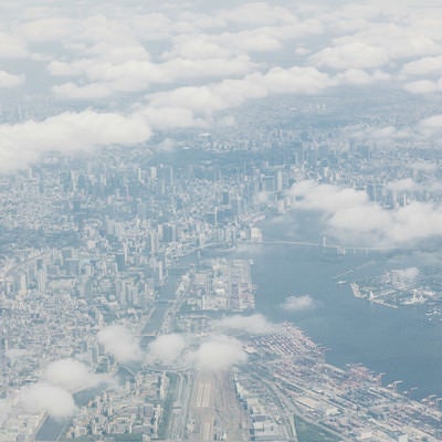 雲の切れ目から見える東京の高層ビル郡の写真