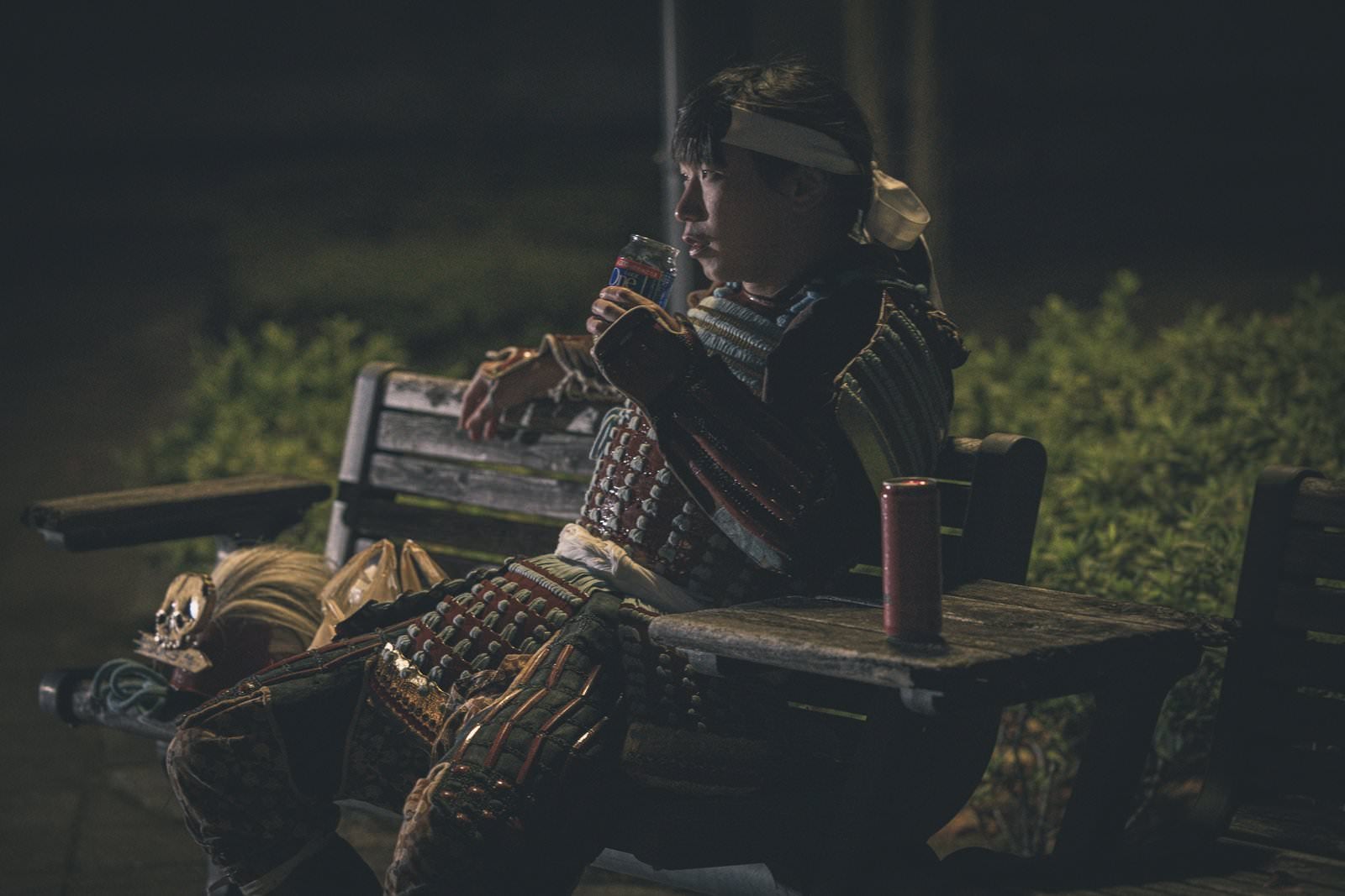 「夜の公園ベンチに腰かけて日本酒に舌鼓をうつ侍」の写真［モデル：まーこ］