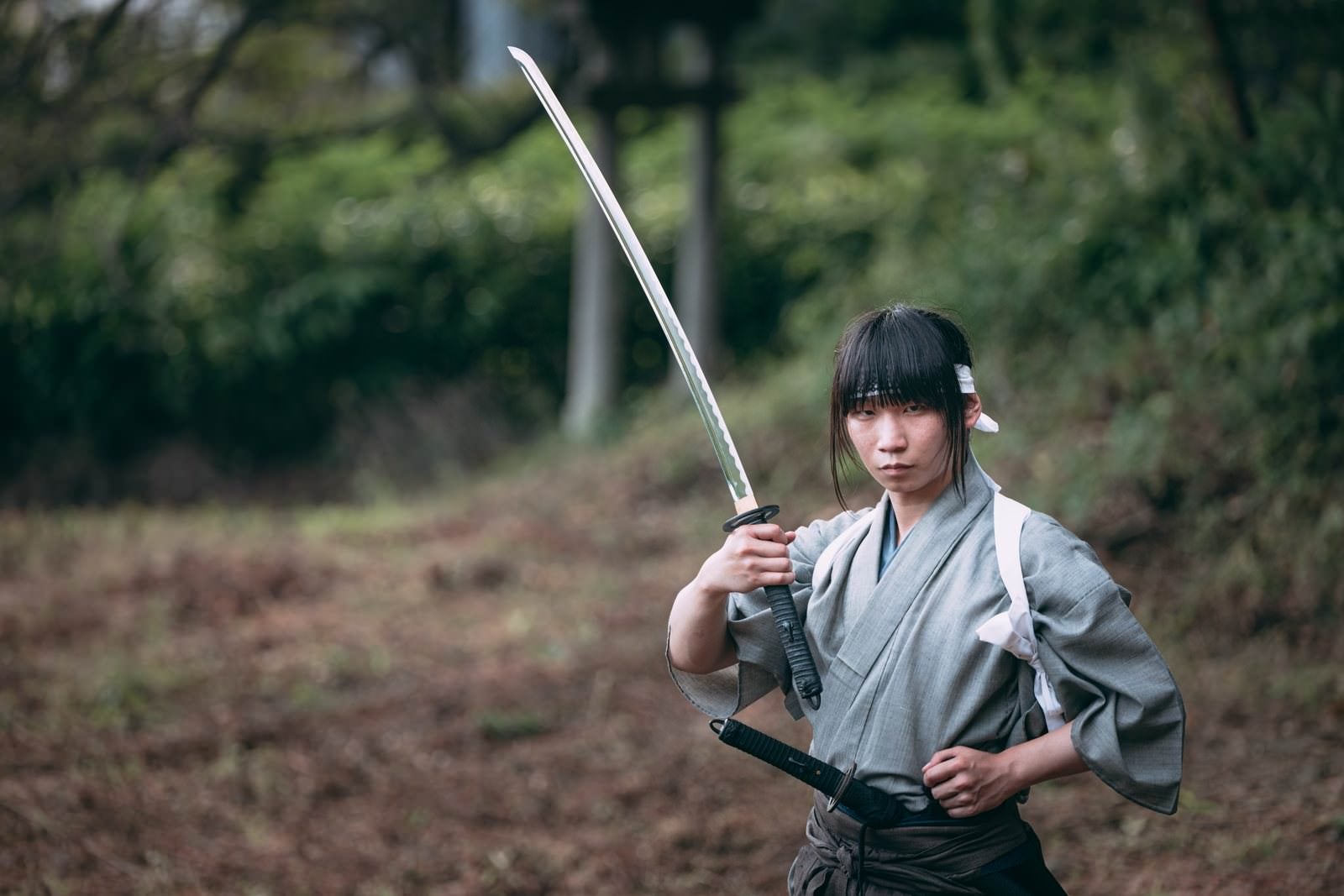 「左手を腰に当て日本刀を手にする侍」の写真［モデル：まーこ］