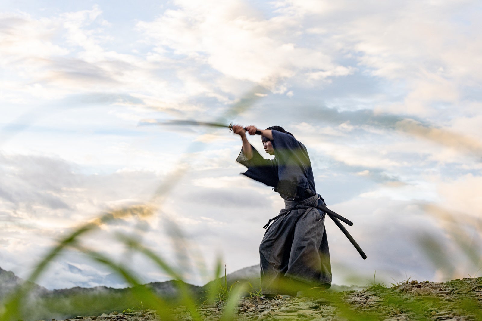 「日本刀で空を切り稽古に励む侍」の写真［モデル：まーこ］