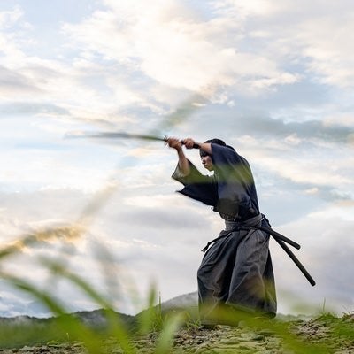 日本刀で空を切り稽古に励む侍の写真