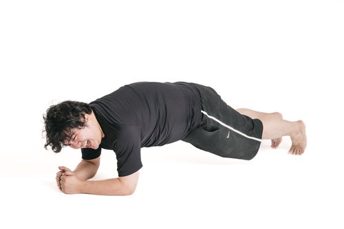 体幹トレーニング「プランク」でつらい表情の男性の写真
