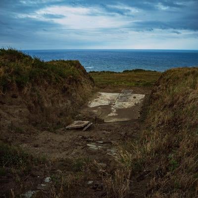 塹壕の先に広がる海の景色の写真