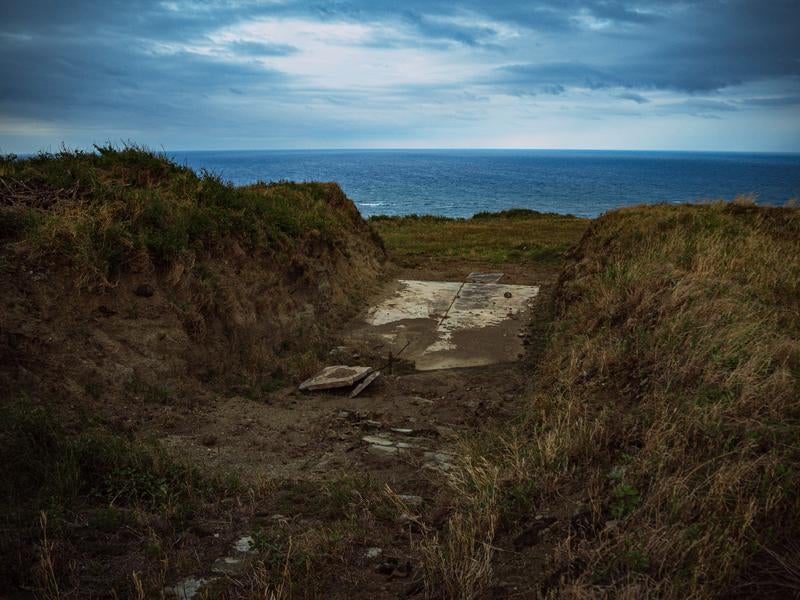 塹壕の先に広がる海の景色の写真