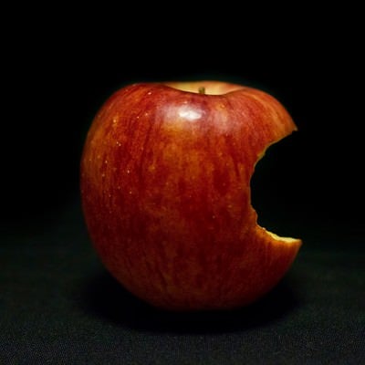 片側をかじられた林檎（Apple）の写真