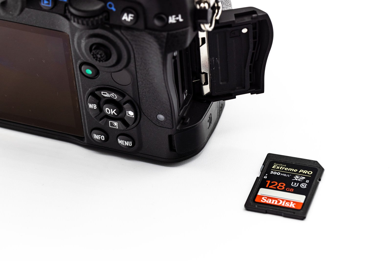 「カメラボディと高速連写に対応する128GBのサンディスクのSDメモリーカード」の写真