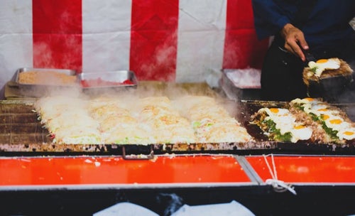 鉄板いっぱいのお好み焼き（屋台）の写真