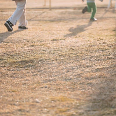 天神岬スポーツ公園でおにごっこをして遊ぶ親子の写真