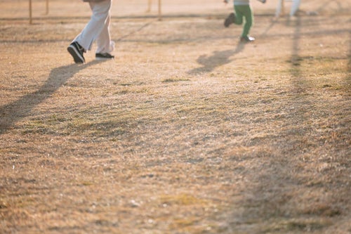 天神岬スポーツ公園でおにごっこをして遊ぶ親子の写真