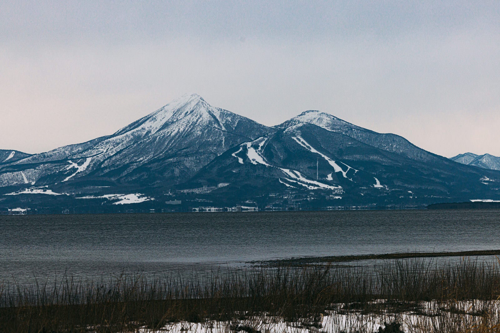 「雪が残る2月上旬の磐梯山と猪苗代湖」の写真
