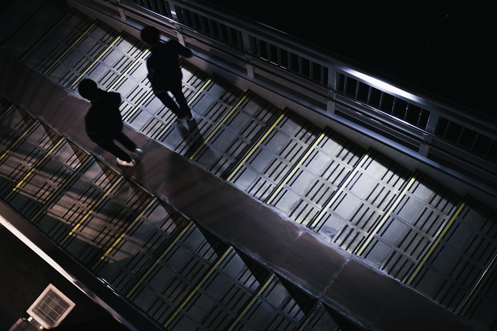「暗い歩道橋を降りる二人組」の写真