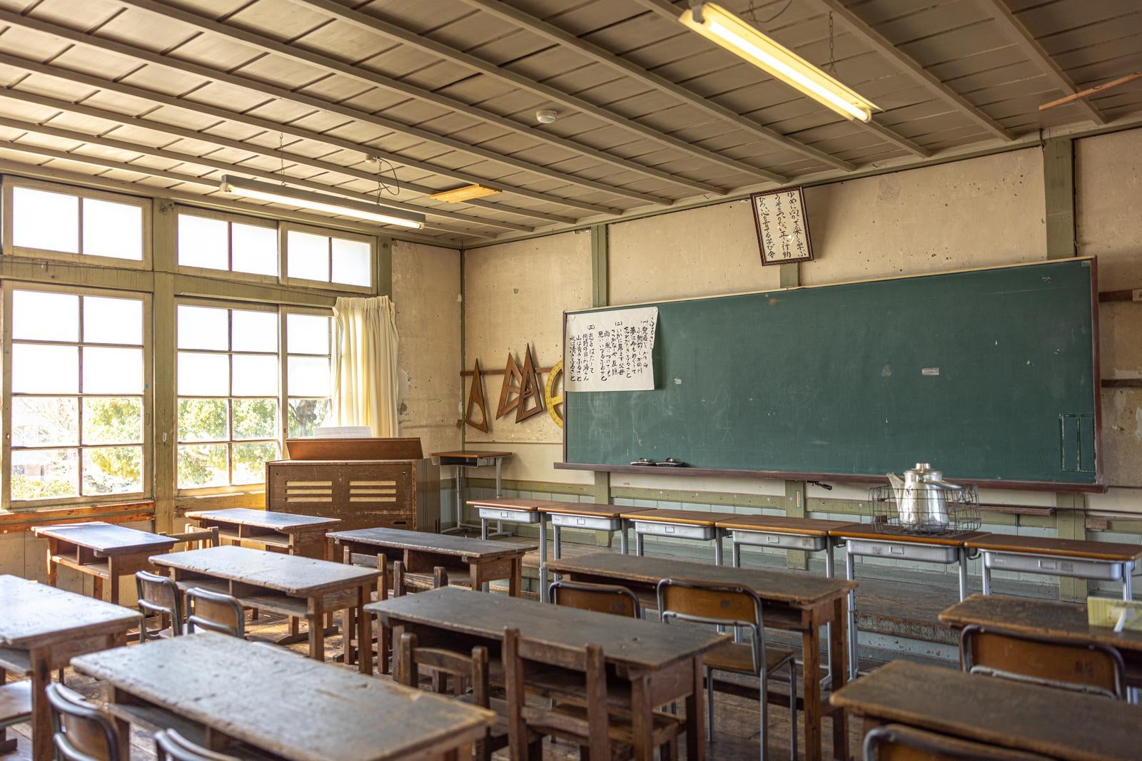 「旧遷喬尋常小学校の黒板と学習机と椅子の配置」の写真
