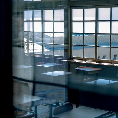 窓ガラス越しの放課後の教室風景の写真