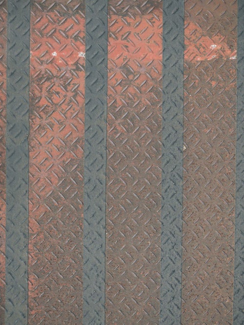 ライン入りの錆び付いた縞鋼板の写真