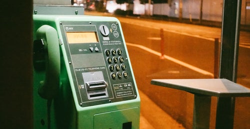 使わなくなった緑の公衆電話の写真
