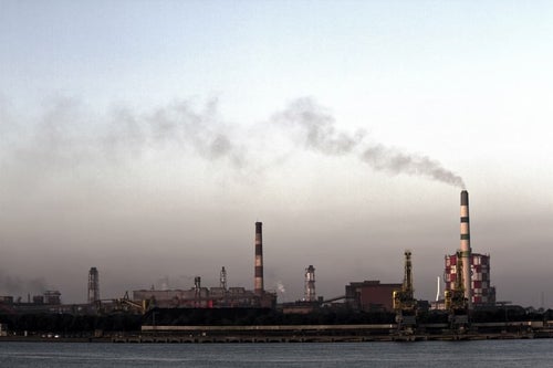 禍々しい空と対岸の工場の写真