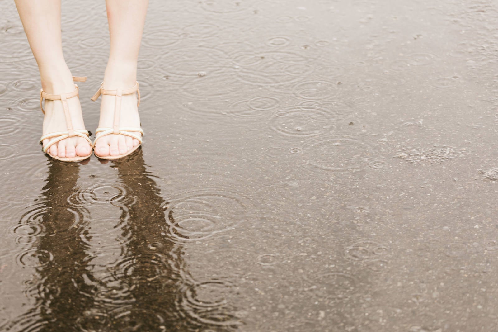 「雨で足元がびしょ濡れの女性」の写真［モデル：佐竹PP］