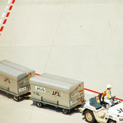 空港のコンテナを運ぶ車の写真