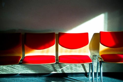 無機質な赤いベンチの写真