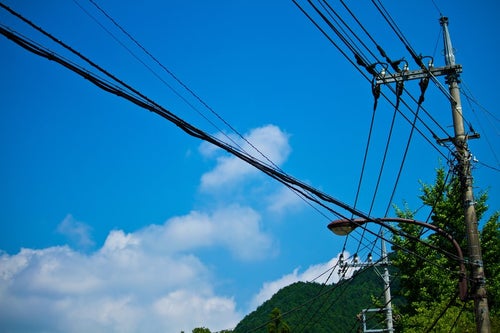 真夏の青空と電柱・電線の写真