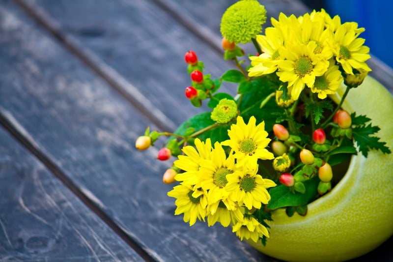 丸い花瓶の黄色い花の写真