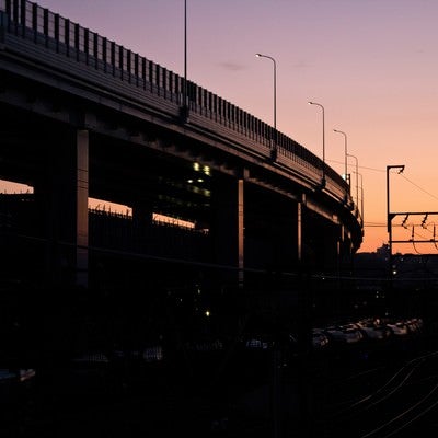夕暮れの高架と線路の写真