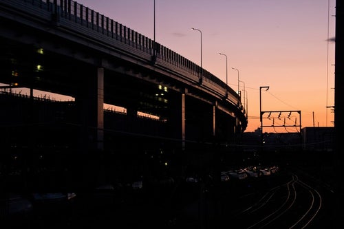 夕暮れの高架と線路の写真