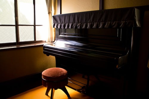 窓際の古いピアノの写真