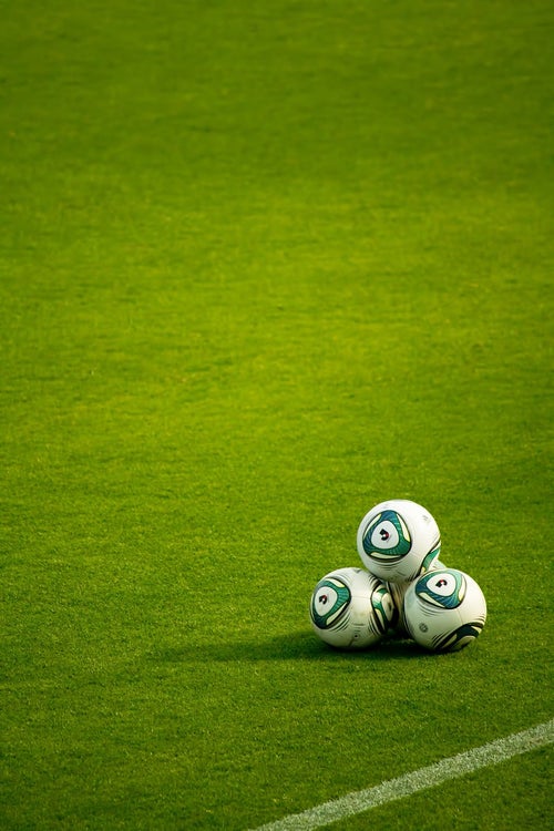 グランドに置かれたサッカーボールの写真