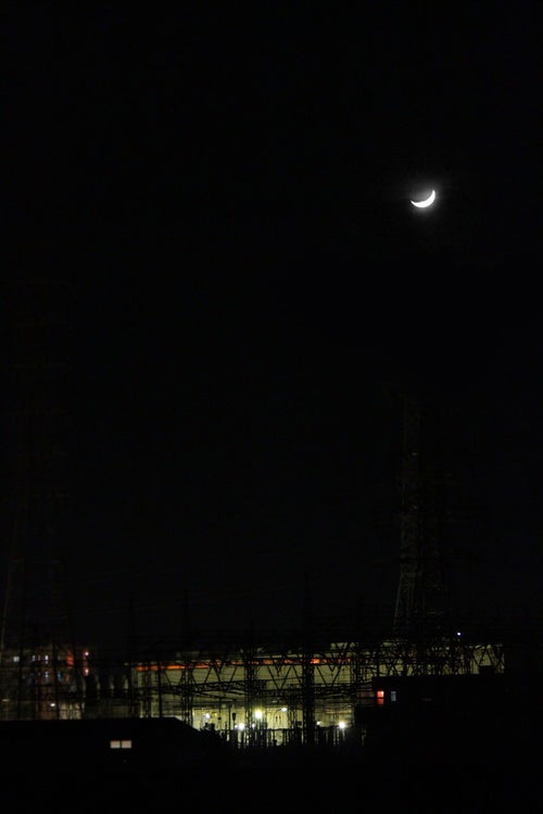三日月と工場（夜間）の写真
