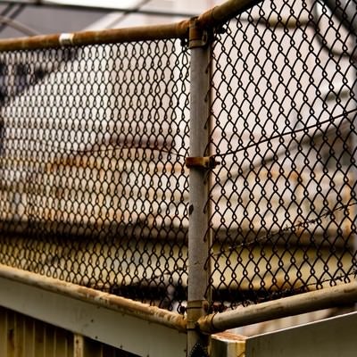 錆びた金網のフェンスの写真