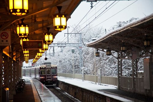 雪の中を通過する電車の写真