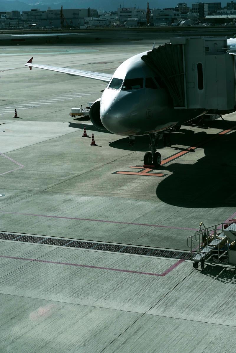 ボーディングブリッジが接続された停機中の飛行機の写真