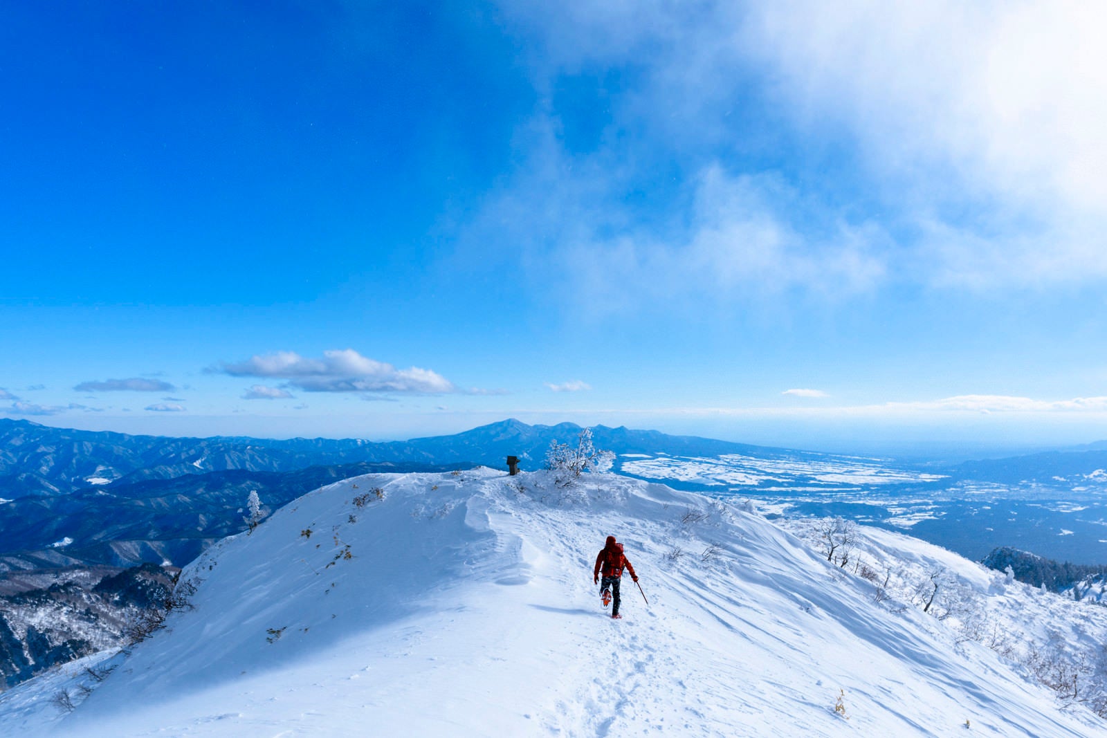 「雪原で駆け出す登山者（上州武尊山）」の写真