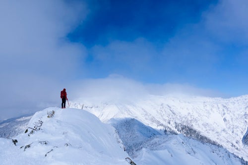 冬の上州武尊山を拝む登山者の写真