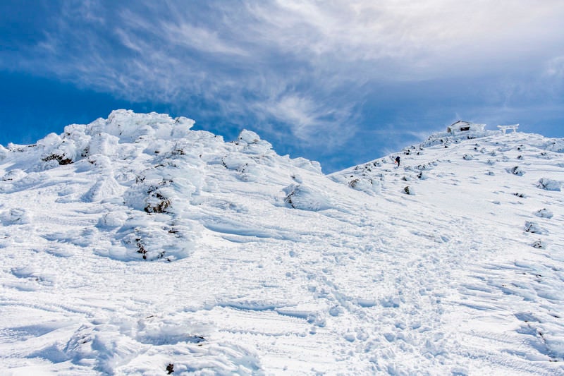 冬の乗鞍岳山頂を目指す登山者の写真