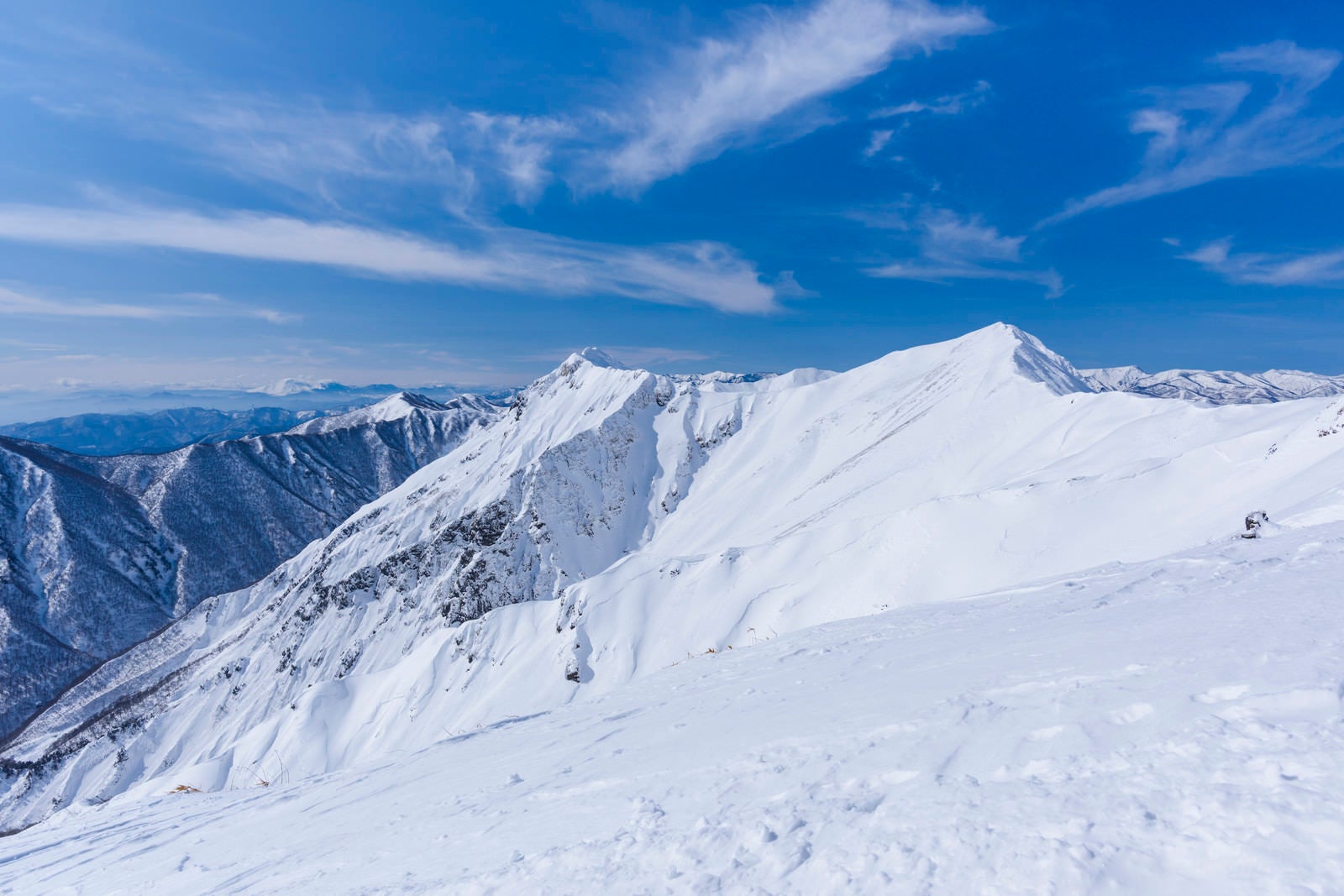「青空の下の雪に包まれた谷川主脈」の写真